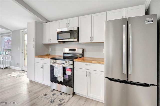 kitchen with white cabinetry, wood counters, appliances with stainless steel finishes, and light hardwood / wood-style floors