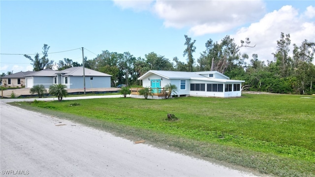 view of front of house featuring a sunroom and a front yard