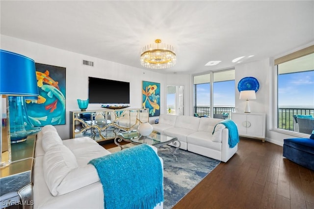 living room with dark wood-style floors, baseboards, visible vents, and a chandelier