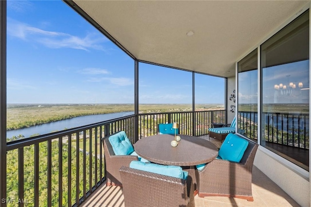 balcony with a sunroom and a water view