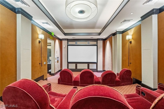 carpeted home theater featuring ornamental molding, a raised ceiling, and visible vents