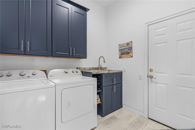 laundry room featuring cabinets, washer and dryer, and sink