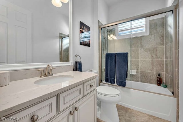 full bathroom featuring toilet, vanity, bath / shower combo with glass door, and tile patterned flooring