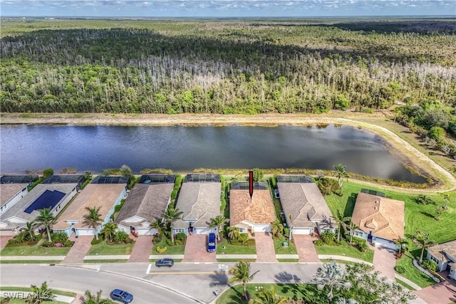 birds eye view of property featuring a water view and a wooded view