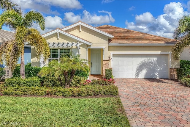 view of front of home featuring an attached garage, decorative driveway, and stucco siding