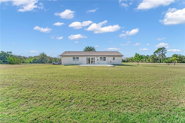 rear view of property featuring a lawn