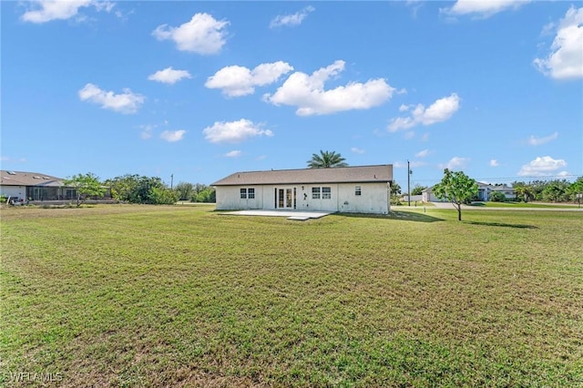 back of house featuring a patio and a lawn