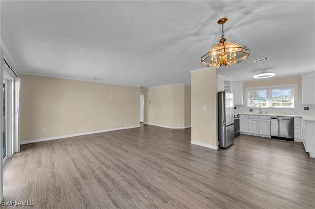 unfurnished living room with sink, dark wood-type flooring, and a chandelier