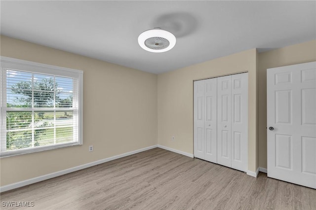 unfurnished bedroom with a closet and light hardwood / wood-style flooring