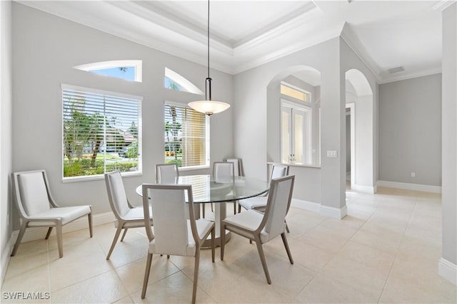 dining space with arched walkways, baseboards, light tile patterned flooring, and crown molding