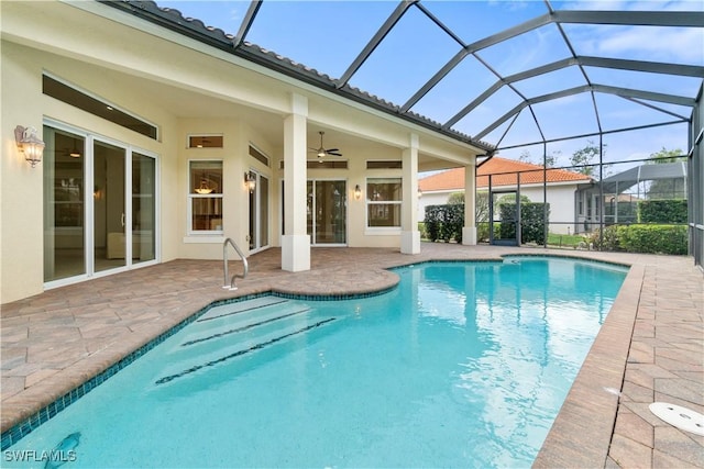 outdoor pool with ceiling fan, glass enclosure, and a patio