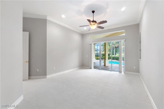 empty room with light colored carpet, crown molding, and baseboards