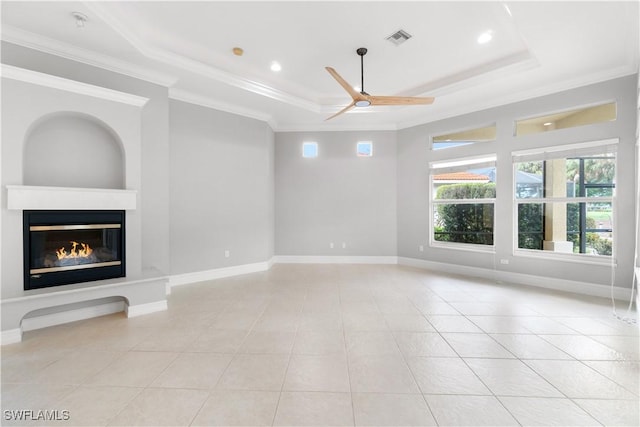 unfurnished living room featuring a ceiling fan, light tile patterned floors, ornamental molding, visible vents, and a tray ceiling