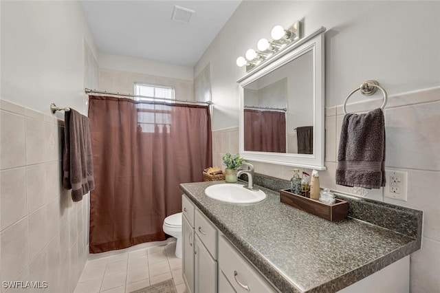 bathroom featuring tile walls, vanity, tile patterned flooring, and toilet