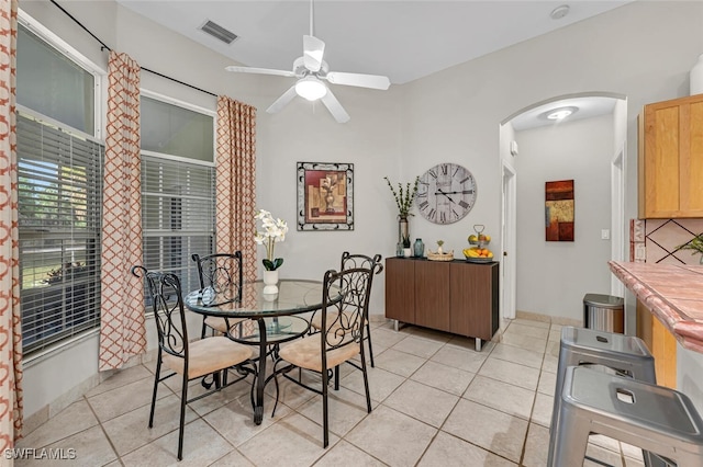 dining space with light tile patterned floors and ceiling fan