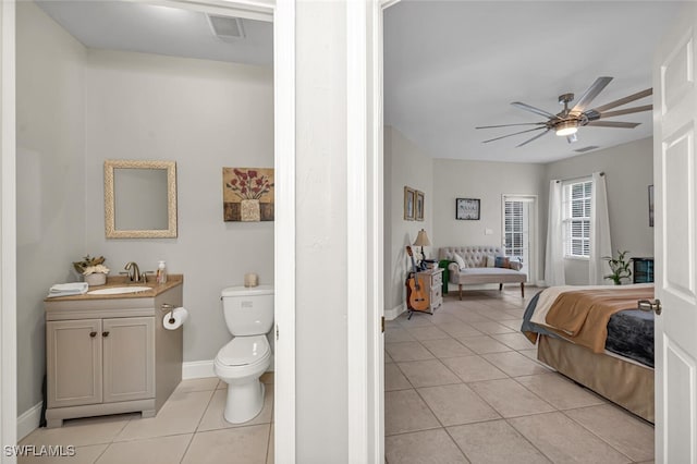 bathroom with tile patterned flooring, vanity, ceiling fan, and toilet