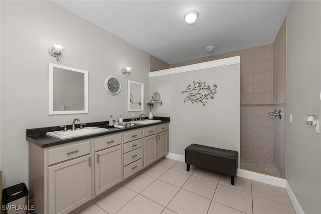 bathroom featuring tile patterned floors, vanity, and a tile shower