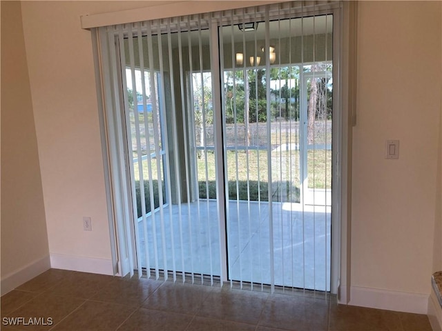 doorway featuring dark tile patterned flooring