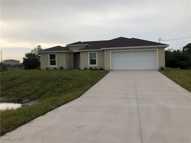 ranch-style house with a garage and a front lawn