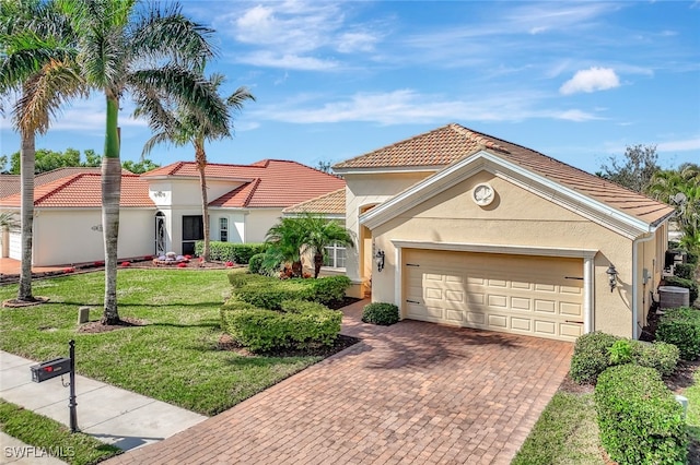 mediterranean / spanish home with cooling unit, a garage, and a front yard