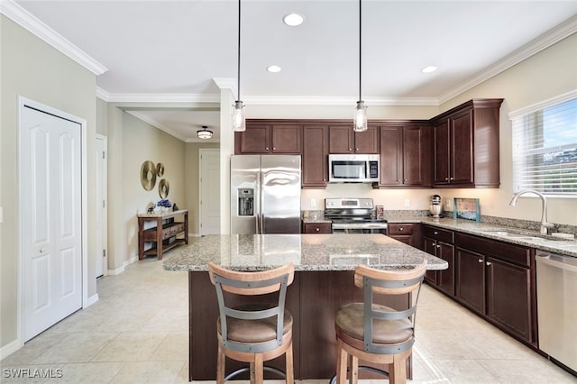 14558 Manchester Dr, Naples, FL 34114 - kitchen featuring appliances with stainless steel finishes, pendant lighting, sink, a center island, and light stone counters