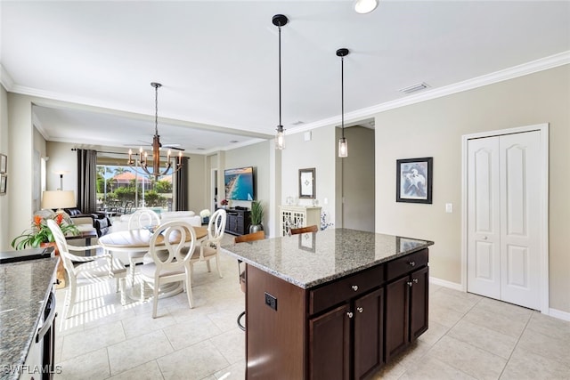 14558 Manchester Dr, Naples, FL 34114 - kitchen with decorative light fixtures, dark brown cabinets, dark stone countertops, ornamental molding, and a kitchen island