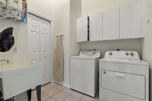 clothes washing area featuring cabinets, separate washer and dryer, sink, and light tile patterned floors