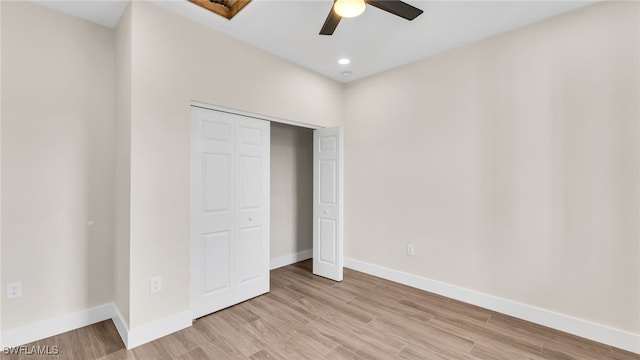 unfurnished bedroom featuring ceiling fan, light hardwood / wood-style floors, and a closet