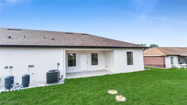 back of property with cooling unit, a patio, and a lawn