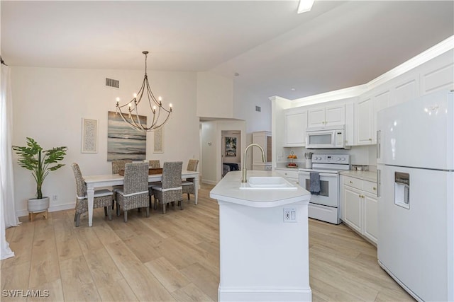 kitchen with a sink, visible vents, white appliances, and light wood-style floors