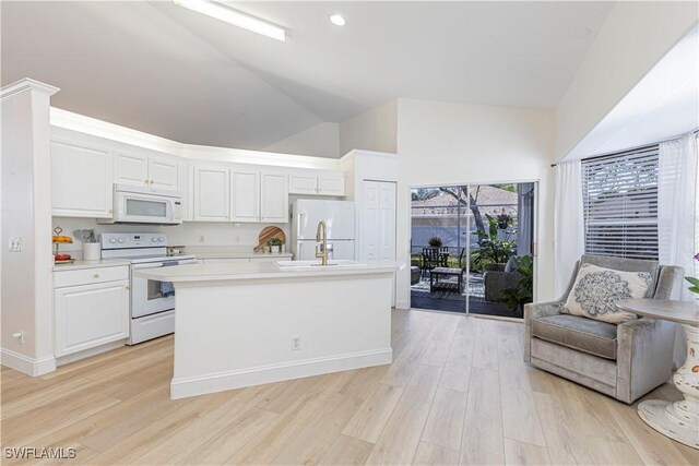 kitchen featuring white appliances, light wood-style flooring, light countertops, white cabinetry, and open floor plan