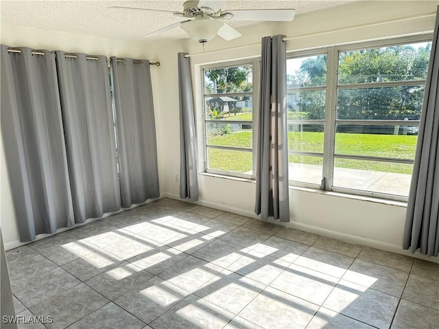 unfurnished room featuring ceiling fan and a textured ceiling