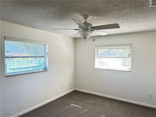 empty room with ceiling fan, carpet floors, and a textured ceiling