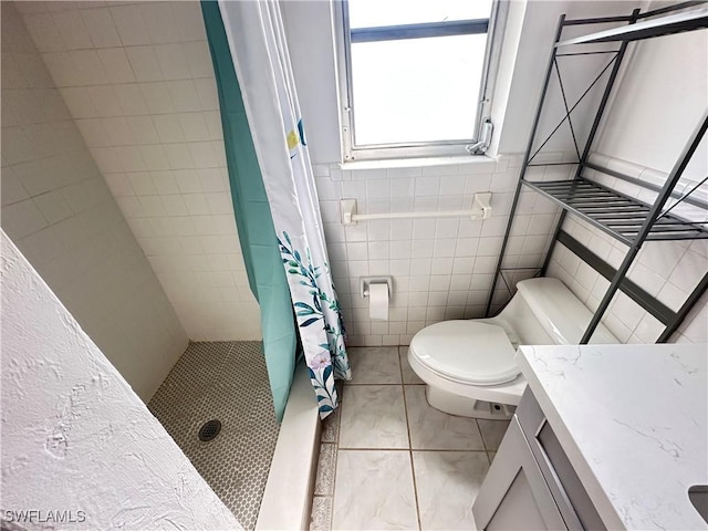 bathroom with a shower with curtain, vanity, tile walls, and toilet