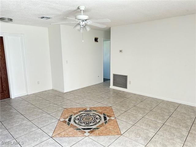 spare room featuring light tile patterned flooring, a textured ceiling, and ceiling fan