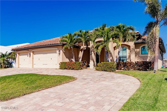 mediterranean / spanish-style house featuring a garage and a front yard