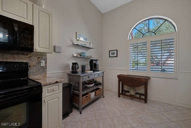 kitchen featuring white cabinetry, a wealth of natural light, black appliances, and light tile patterned flooring