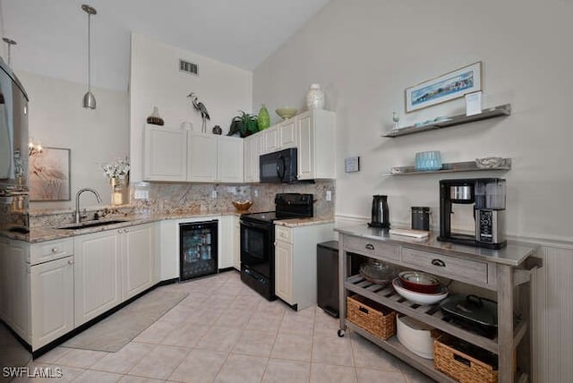 kitchen with decorative light fixtures, white cabinetry, sink, wine cooler, and black appliances