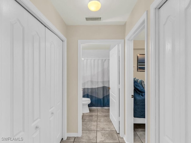 bathroom with a shower with curtain, tile patterned floors, and toilet