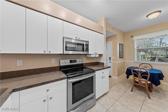 kitchen with white cabinetry, stainless steel appliances, and light tile patterned flooring