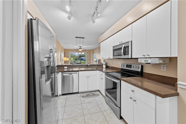 kitchen featuring sink, light tile patterned floors, white cabinets, and appliances with stainless steel finishes