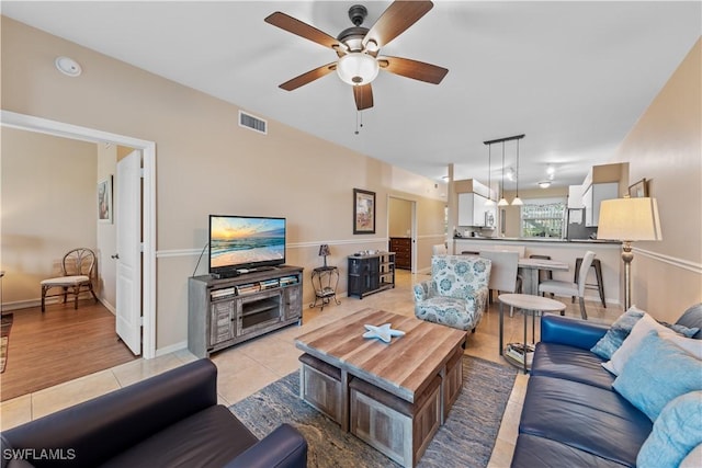 tiled living room with ceiling fan