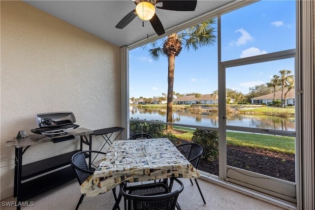 sunroom / solarium with a water view, a healthy amount of sunlight, and ceiling fan