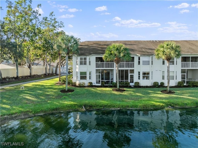 rear view of property with a yard and a water view