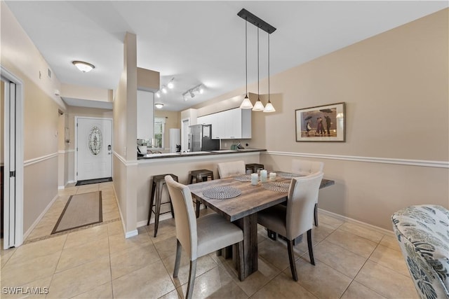 dining room with rail lighting and light tile patterned floors