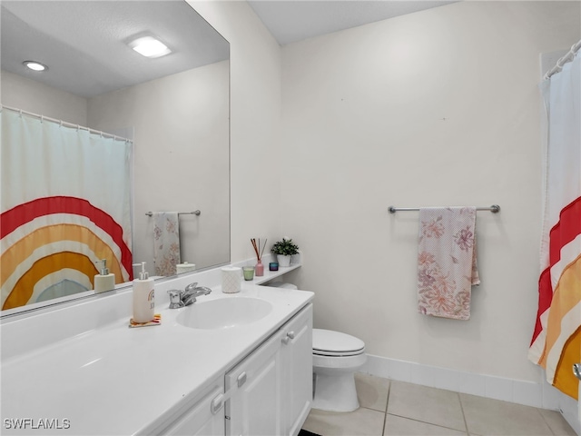 bathroom featuring baseboards, vanity, toilet, and tile patterned floors