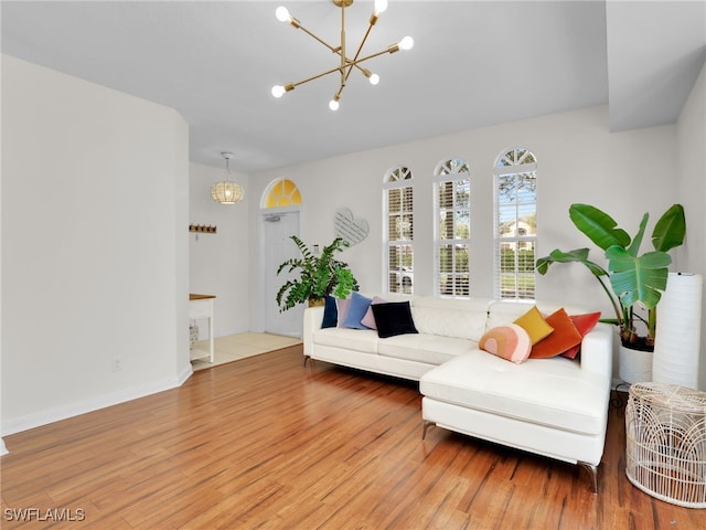 sitting room with an inviting chandelier, baseboards, and wood finished floors