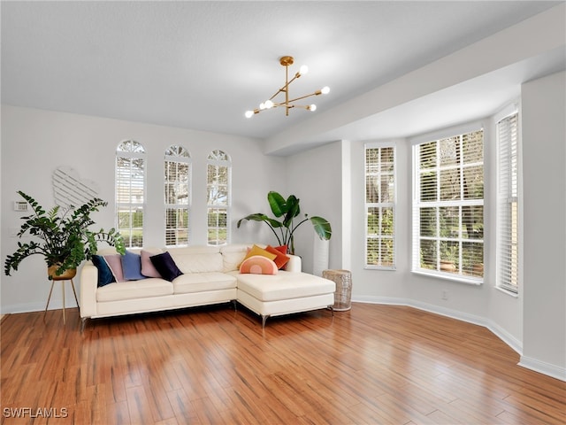 interior space with a healthy amount of sunlight, wood finished floors, and a notable chandelier