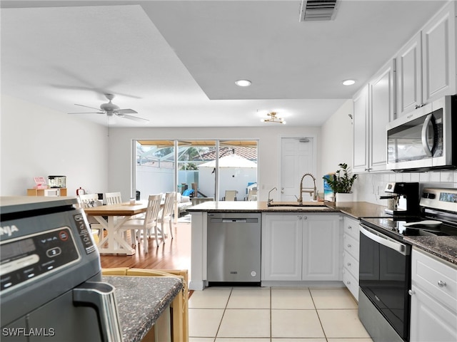 kitchen with appliances with stainless steel finishes, a sink, visible vents, and white cabinets