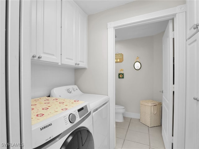 washroom with light tile patterned floors, washing machine and clothes dryer, cabinet space, and baseboards